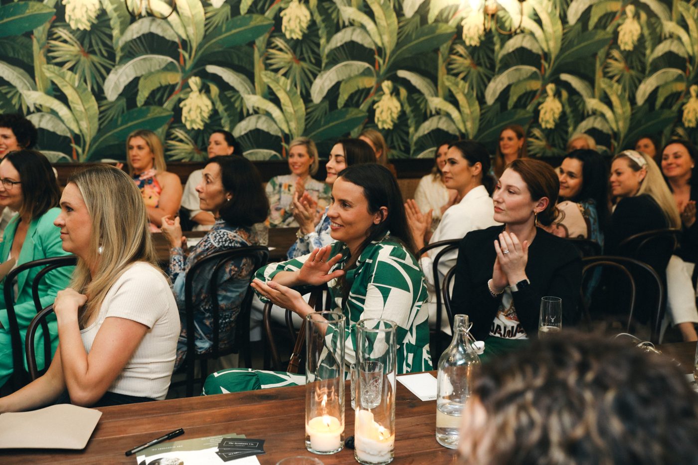 Guests smiling and applauding during a talk at a Lady Counsel event