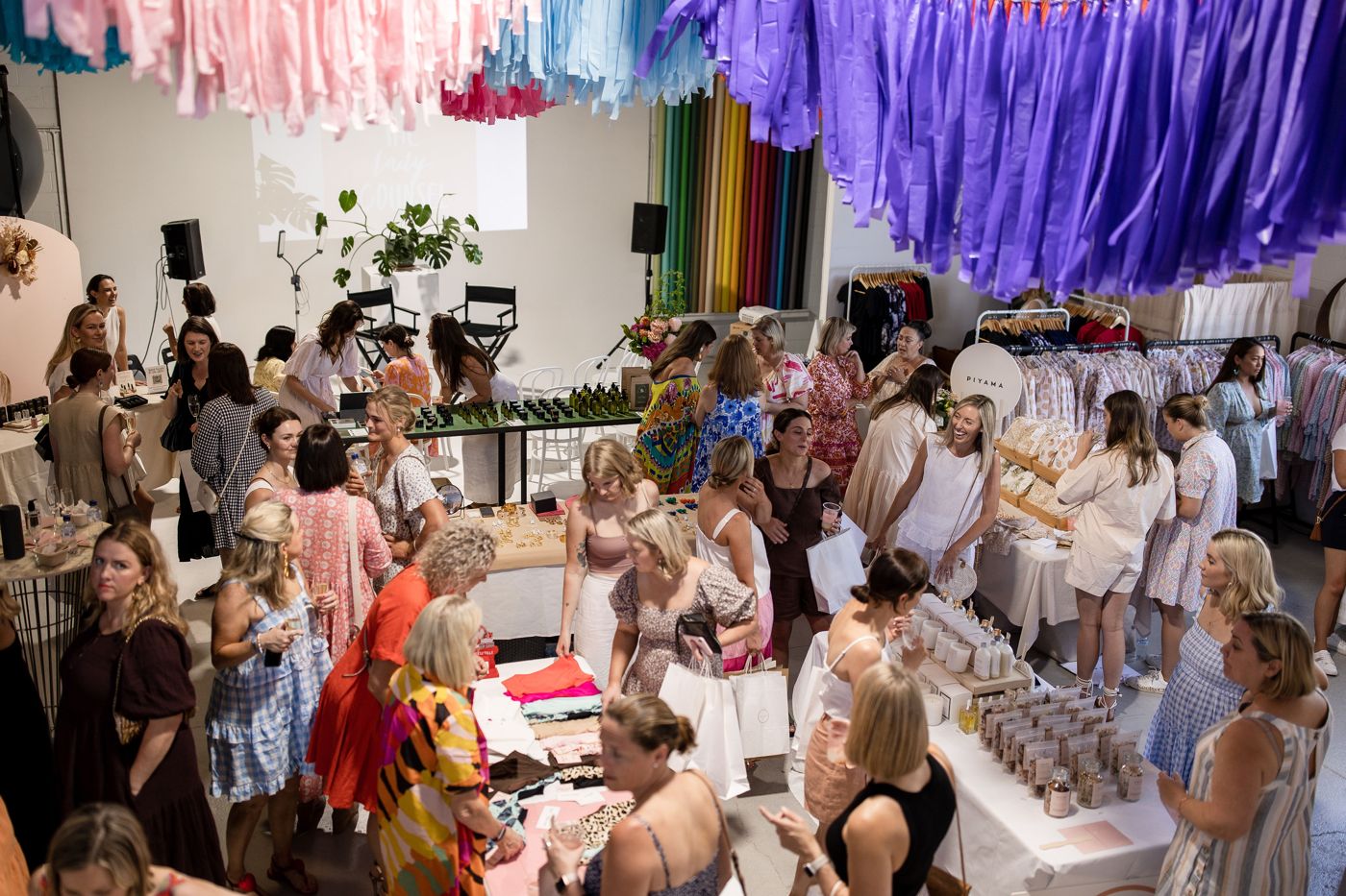 Shoppers browsing stalls at a Lady Counsel market