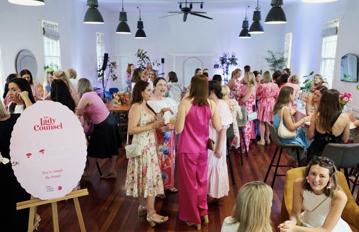Guests mingling at a Lady Counsel event beside a Lady Legends welcome sign